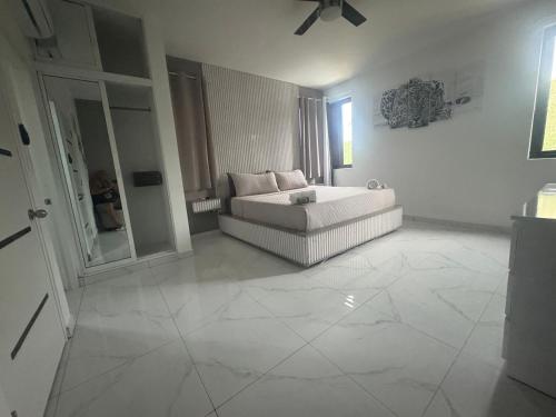 a white living room with a couch and a window at LEVEL suites in Sosúa