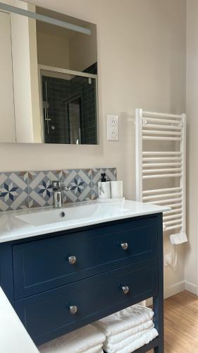 a bathroom with a blue sink and a mirror at T2 chaleureux au centre de la ville in Rouen