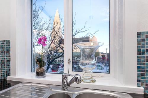 a sink and a window with a vase on a window sill at Freyja Guesthouse & Suites in Reykjavík
