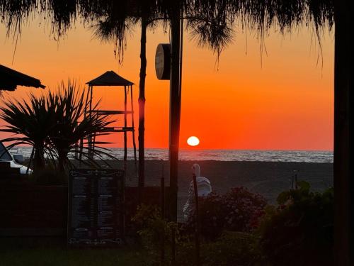 a sunset on the beach with the sun setting at Shtepia Druri Sokol Lulaj in Lezhë