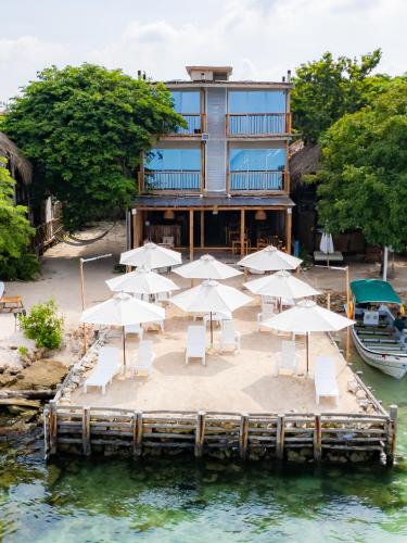 a group of umbrellas and chairs on a dock in the water at Mar Barú Beach House in Playa Blanca