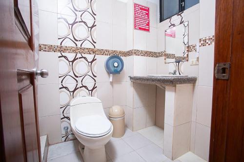 a bathroom with a toilet and a sink at Hostal casa de los delfines in Puerto Villamil
