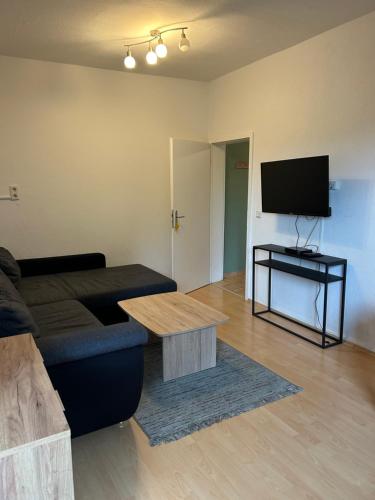 un salon avec un canapé et une télévision à écran plat dans l'établissement City Monteur Apart, à Homberg