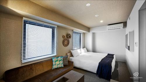 a small bedroom with a bed and a couch at DEL style Osaka Higashi Temma by Daiwa Roynet Hotel in Osaka