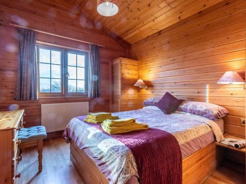 a bedroom with a bed in a log cabin at 2 Bed in Clovelly 00361 in Clovelly