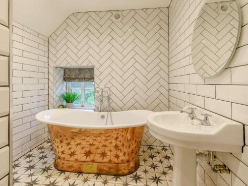 a bathroom with a tub and a sink at 4 Bed in Cromford 82198 in Cromford