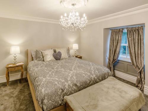 a bedroom with a bed and a chandelier at 4 Bed in Cromford 82198 in Cromford