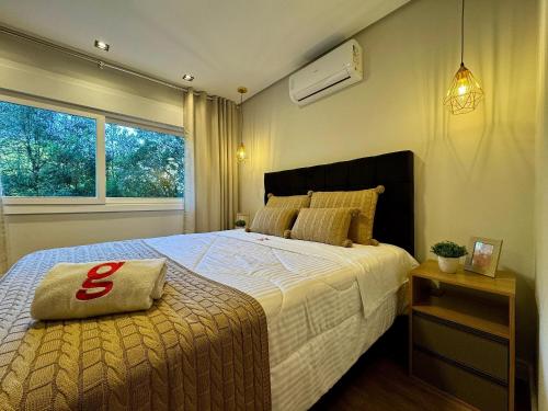 a bedroom with a large bed and a window at Delle Alpi 117 - Apartamento novo junto a Nasa e roda-gigante in Canela