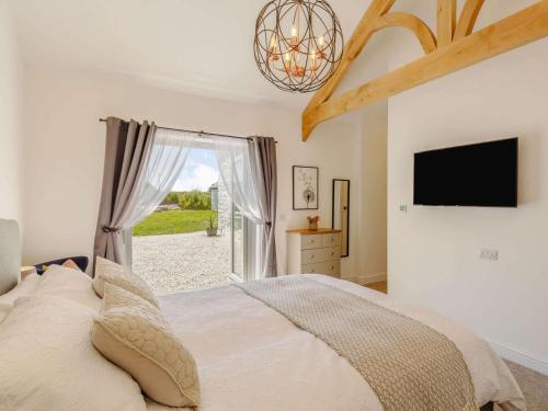 a bedroom with a bed and a tv and a window at 3 Bed in Porthtowan 88102 in Redruth