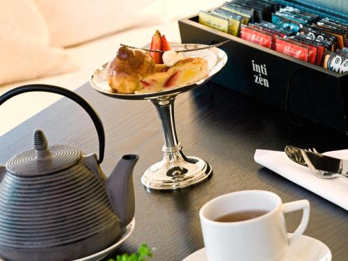 a table with a plate of food and a cup of tea at Sofitel La Reserva Cardales in Río Luján