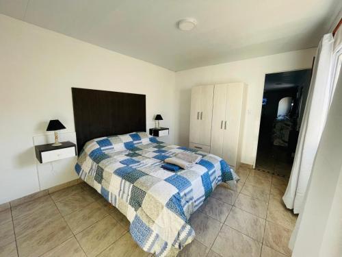 a bedroom with a bed with a blue and white blanket at Apartment with garage, for 4 people, 3 blocks from the Hospital in RSA