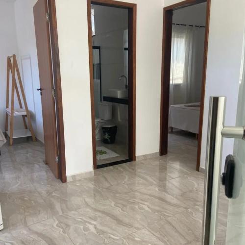 un couloir avec un miroir et une salle de bains avec un lavabo dans l'établissement Apart Lua Cheia 2 quartos caminho das praias, à Itacaré