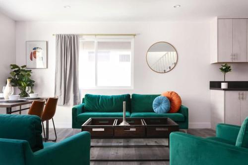 a living room with a green couch and a table at Relax in Spacious 3BR Apt Sleeps 8 and Parking in Glendale