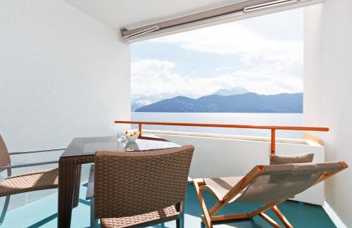 a balcony with a table and chairs on a ship at Post Hotel Weggis in Weggis
