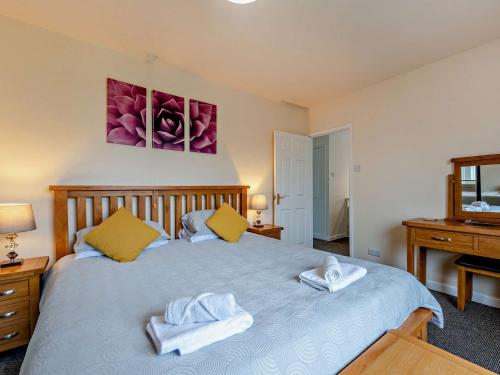 a bedroom with a bed with towels on it at 5 bed in Brynteg 75907 in Llanwenog