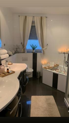a bathroom with white sinks and a tub and a window at Black Forest Oase in Gaggenau