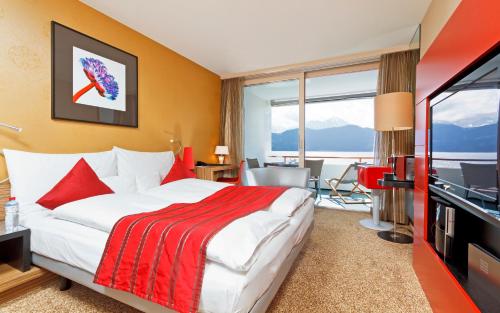 ヴェッギスにあるPost Hotel Weggisのベッドとテレビが備わるホテルルームです。