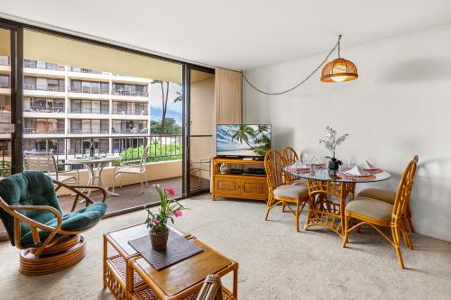 a living room with a television and a table and chairs at Sugar Beach 304 in Kihei