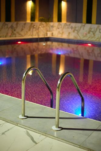 una piscina con due maniglie di metallo davanti alla piscina di Résidence HQ a Brazzaville