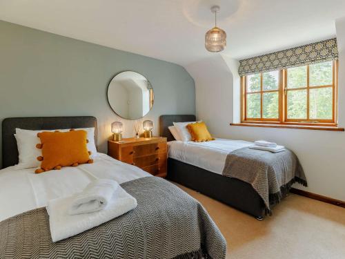 a bedroom with two beds and a mirror at 4 Bed in Oswestry 88850 in Llanyblodwel