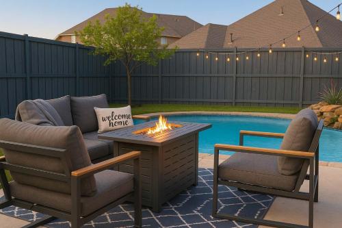 a patio with two chairs and a table with a fire pit at Texan Sunny Oasis 5 BED Private Pool Hot tub in Rowlett