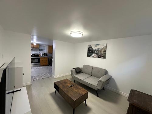 Una sala de estar con un sofá y una mesa de café. en Modern 2 Bedroom Suite, Excellent Location Near Downtown & Airport, en Kitchener