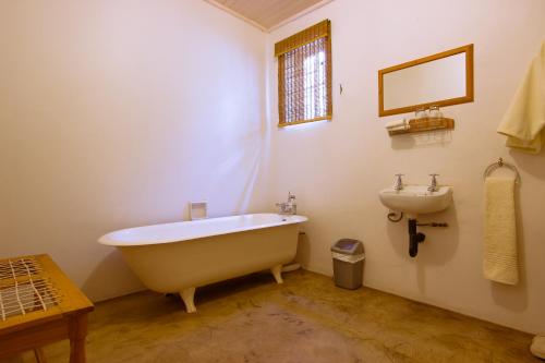 a bathroom with a bath tub and a sink at The Barracks in Colesberg