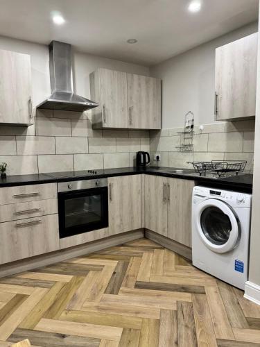 a kitchen with a washing machine and a washer at Stylish 2 Bed Apt Near Birmingham in Birmingham