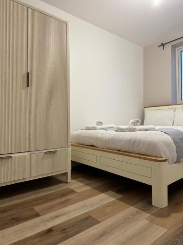 ein Schlafzimmer mit einem Bett und einem großen Schrank in der Unterkunft Near Birmingham - Stylish Retreat - Free parking in Birmingham