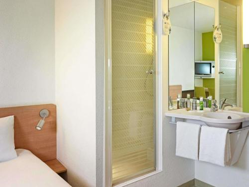a bathroom with a sink and a mirror at ibis budget Wrocław Południe in Wrocław