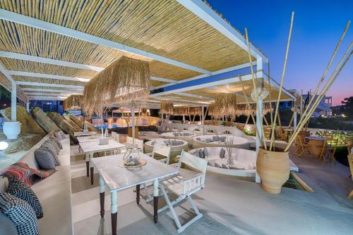 a restaurant with tables and chairs on a boat at Kouros Exclusive Hotel & Suites - Adults Only in Faliraki