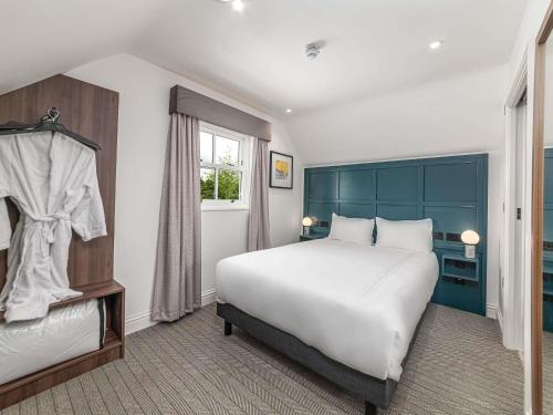 a bedroom with a large white bed and a window at Mercure Salisbury White Hart Hotel & Apartments in Salisbury