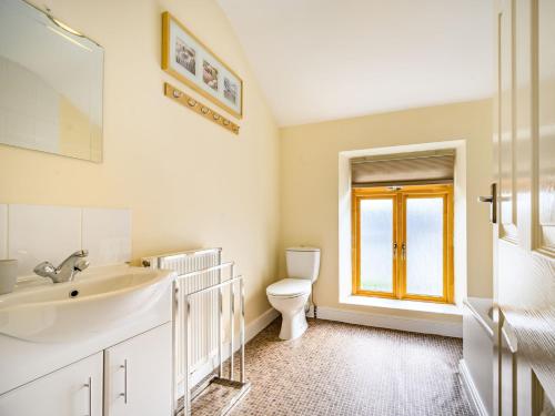 Un baño con lavabo, inodoro y ventana. en 1 Bed in Cockermouth 87480, en Cockermouth