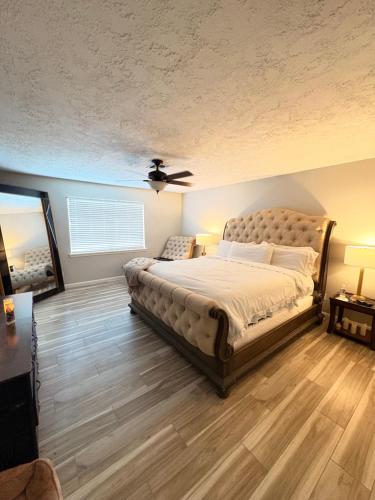 ein Schlafzimmer mit einem Bett und einem Deckenventilator in der Unterkunft Affordable 4 bedrooms home with a pool! in Houston