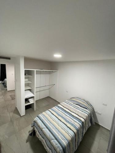 Un dormitorio con una cama y una pared blanca. en Casa bbb, en Chihuahua