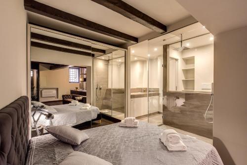 ローマにあるTrinità dei Monti Suiteのベッド2台とシャワーが備わる客室です。