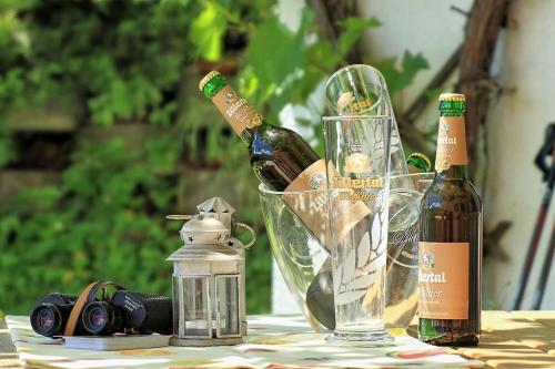 una mesa con dos botellas de vino y una copa en Hotel Pension Eichenhof, en Fügenberg