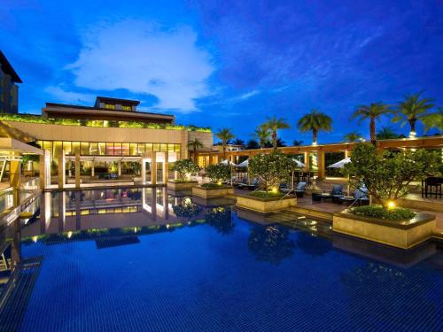 a pool in front of a hotel at night at Novotel Hyderabad Airport in Hyderabad