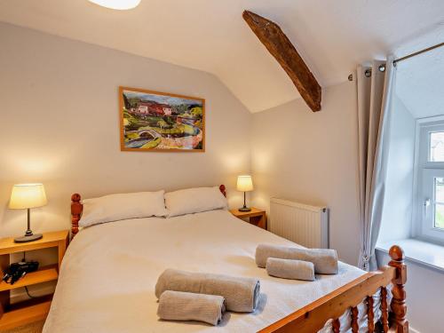 a bedroom with a large bed with two pillows on it at 2 Bed in Llangynidr BN052 in Llangynidr