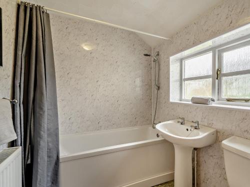 a bathroom with a sink and a bath tub and a toilet at 2 Bed in Llangynidr BN052 in Llangynidr