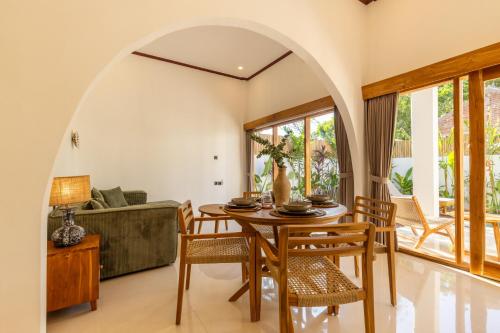 een eetkamer met een tafel en stoelen bij Villa Suka in Kuta Lombok