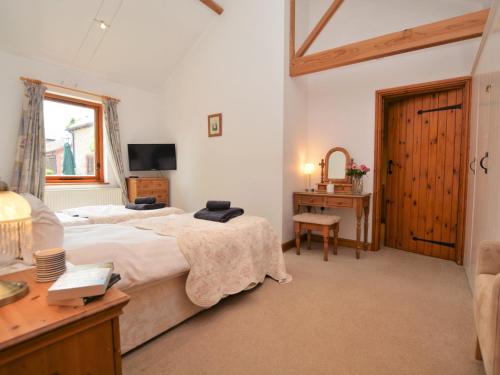 a bedroom with a bed and a desk and a window at 2 Bed in Sherborne FOLWO in Long Burton