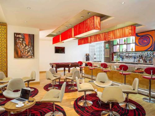 a bar with chairs and a piano in a room at ibis Bengaluru Hosur Road - An Accor Brand in Bengaluru
