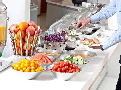 a buffet with fruits and vegetables in bowls on a counter at ibis Bengaluru Hosur Road - An Accor Brand in Bengaluru