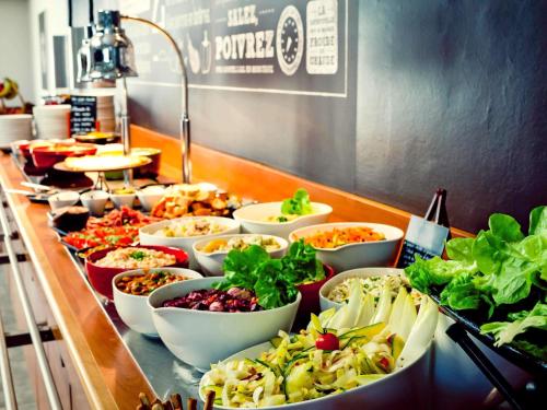 a buffet with many bowls of food on a table at ibis Bengaluru Hosur Road - An Accor Brand in Bengaluru