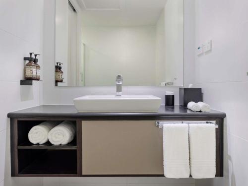 a bathroom with a sink and towels on a counter at Novotel Suva Lami Bay in Suva