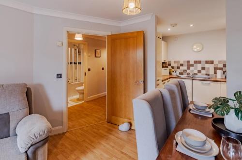 a living room with a dining room table and a kitchen at Contractor-Friendly, Private Gated Parking, Fast WiFi, Sofa Bed & Netflix, 5-Min Walk to City Centre, 15-Min Walk to Train Station, Ideal for Relocators & Families in Coventry
