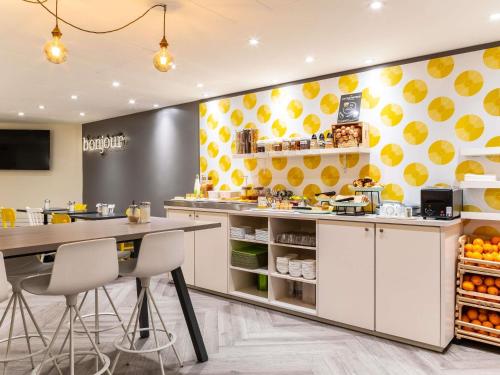 uma cozinha com um balcão com uma mesa e cadeiras em ibis Styles Paris 15 Lecourbe em Paris