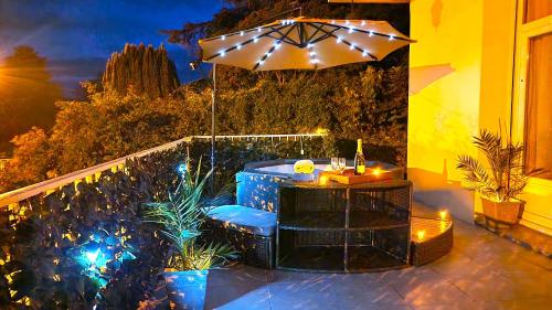 a patio with a table and an umbrella at Maison SPA 8Chambres Jardin Terrasse Parking in Blois