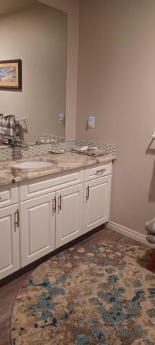 a kitchen with white cabinets and a rug at Deer Ridge B&B in Golden